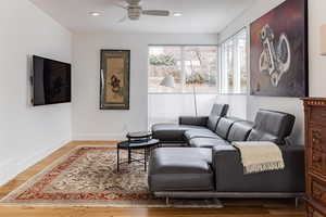 Living room with hardwood / wood-style floors and ceiling fan