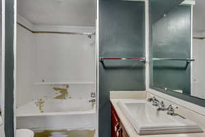 Full bathroom featuring washtub / shower combination, vanity, and toilet