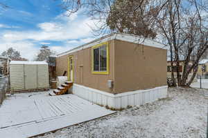 View of snowy exterior featuring a storage shed