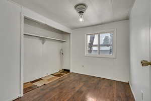 Unfurnished bedroom with dark wood-type flooring and a closet