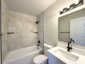 Full bathroom featuring vanity, toilet, and tiled shower / bath