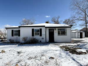 View of front of home featuring a storage shed