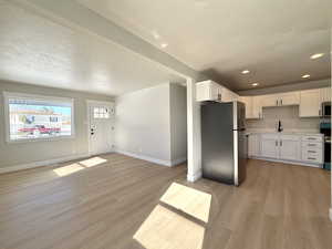 Kitchen featuring white cabinetry, sink, light hardwood / wood-style flooring, and stainless steel appliances