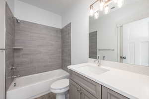 Full bathroom with vanity, tiled shower / bath combo, wood-type flooring, and toilet