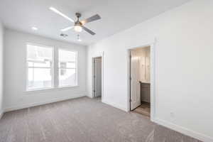 Unfurnished bedroom with ceiling fan, ensuite bath, light carpet, and a textured ceiling