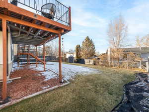 View of backyard with a storage shed, trampoline and steps leading up to deck