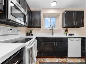 Kitchen with white appliances, quartz counters, beautiful view above double sink