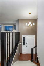 Entrance foyer featuring hardwood / wood-style floors, a notable chandelier, and a textured ceiling