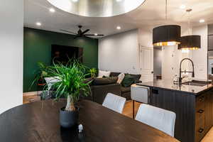 Dining area featuring ceiling fan, sink, and light wood-type flooring