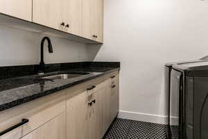 Laundry room with cabinets, separate washer and dryer, and sink