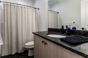 Bathroom featuring vanity, tile patterned flooring, and toilet