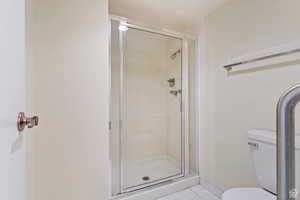 Master Suite #1 Bathroom with tile patterned flooring, toilet, and walk-in shower