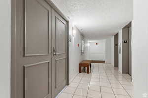 12 th floor unit right off the elevator, a textured ceiling, and light tile patterned floors