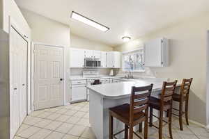 Kitchen with peninsula flowing into large recreation room.