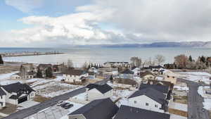 Snowy aerial view featuring a water and mountain view