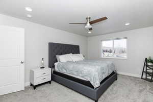 Carpeted bedroom featuring ceiling fan