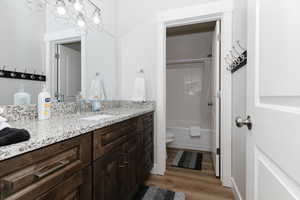 Full bathroom featuring hardwood / wood-style flooring, vanity, shower / bath combo, and toilet