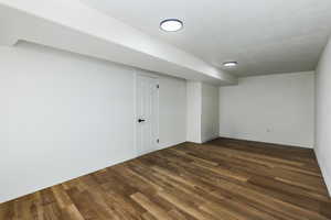 Basement with dark hardwood / wood-style floors