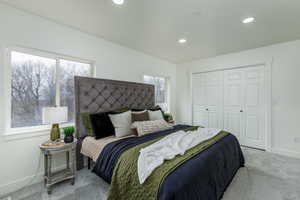 Primary Bedroom with light colored carpet and a closet