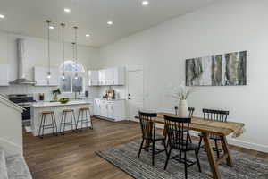 Dining room featuring dark hardwood / wood-style flooring, sink, and a high ceiling