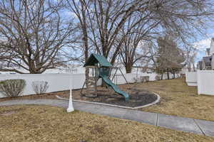 View of jungle gym featuring a lawn