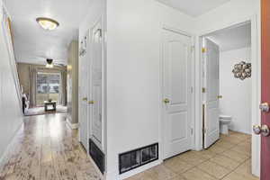 Hallway with light tile patterned flooring and a textured ceiling