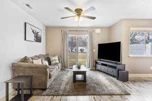 Living room with ceiling fan and light hardwood / wood-style flooring