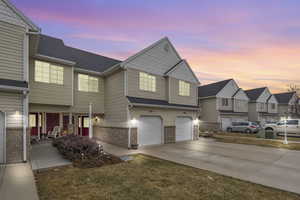 View of front of property with a garage and a lawn