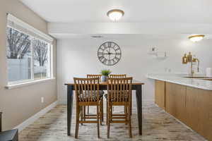 Dining space with sink and light wood-type flooring