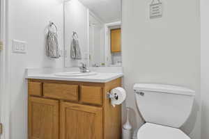 Bathroom with vanity, toilet, and a textured ceiling