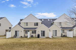 Back of property featuring central AC unit, a lawn, and a patio