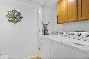 Laundry room featuring cabinets and washing machine and clothes dryer