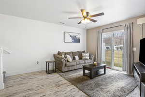 Living room with ceiling fan and light wood-type flooring