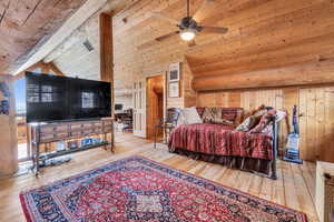 Bedroom featuring wood ceiling, wood walls, lofted ceiling with beams, and light wood-type flooring