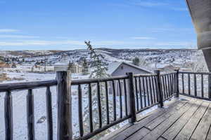 Snow covered deck featuring a mountain view