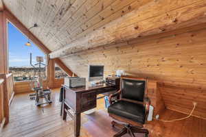 Office with hardwood / wood-style floors, wooden walls, wooden ceiling, and vaulted ceiling