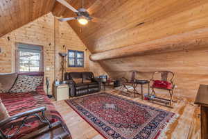 Living room featuring wood ceiling, hardwood / wood-style flooring, high vaulted ceiling, and ceiling fan