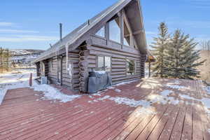 Snow covered deck featuring a grill