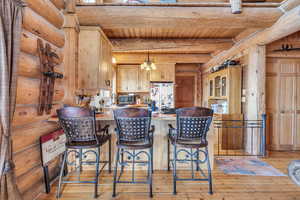 Kitchen featuring pendant lighting, a kitchen bar, white fridge, kitchen peninsula, and light hardwood / wood-style flooring