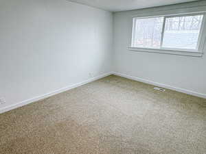 Empty room featuring carpet floors and a textured ceiling