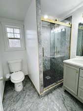 Bathroom with vanity, toilet, a shower with door, and a textured ceiling