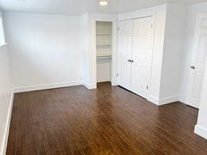 Unfurnished bedroom featuring dark wood-type flooring