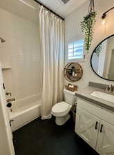 Full bathroom with vanity, shower / bath combination with curtain, tile patterned floors, and toilet