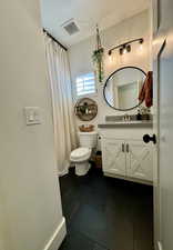 Bathroom featuring tile patterned floors, toilet, vanity, and a textured ceiling