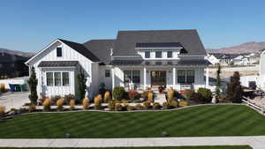 Modern farmhouse style home with a mountain view and a front lawn