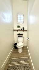 Bathroom with hardwood / wood-style flooring and toilet