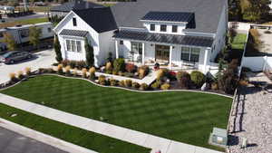 Modern farmhouse style home featuring a front lawn