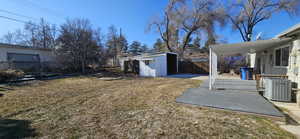 View of yard featuring central AC unit and a storage unit