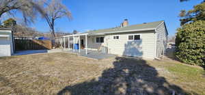 Back of property with a yard and a patio