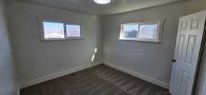 Empty room with carpet floors and a healthy amount of sunlight